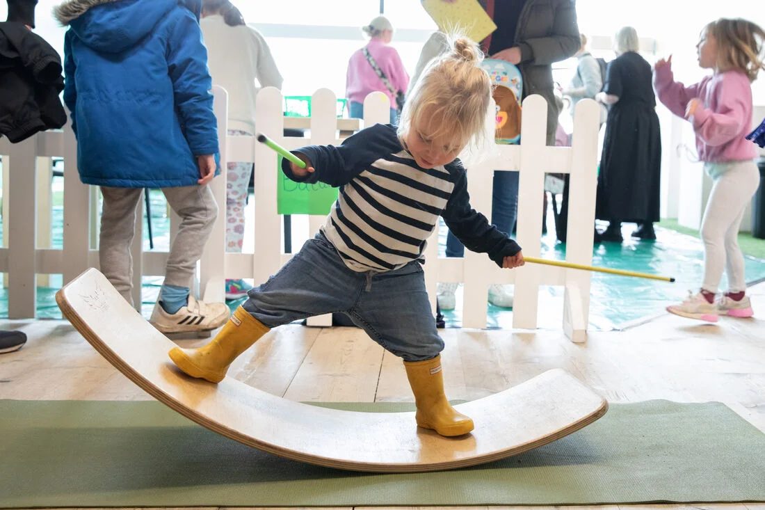 A young girl balances on a wooden seesaw in the one of the light and open spaces at the Baltic.