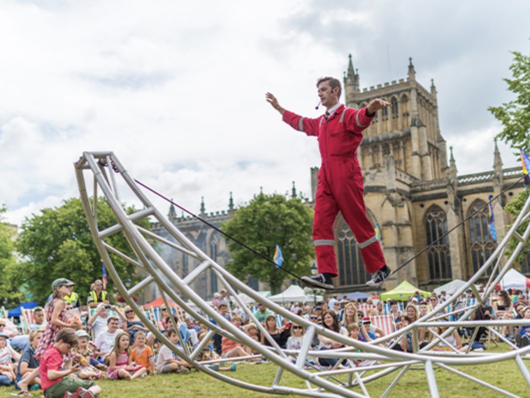 A man precariously balances on a large metal structure.