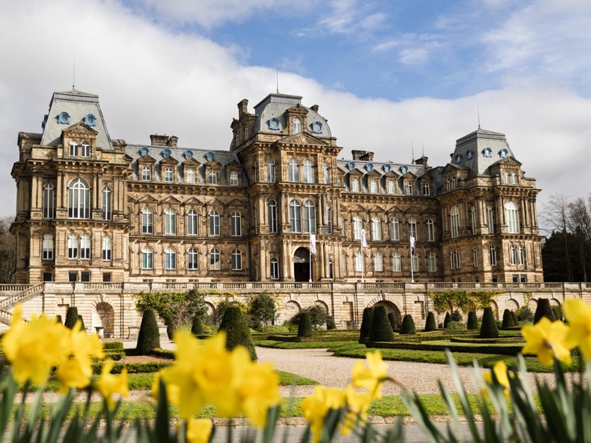 An image of the exterior of The Bowes Museum with daffodils in the foreground.
