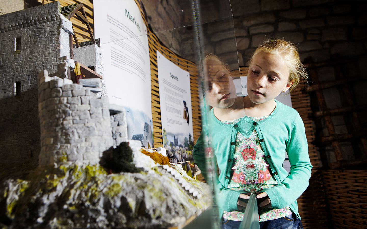 A girl looking at a model bastle house at Hexham Old Gaol