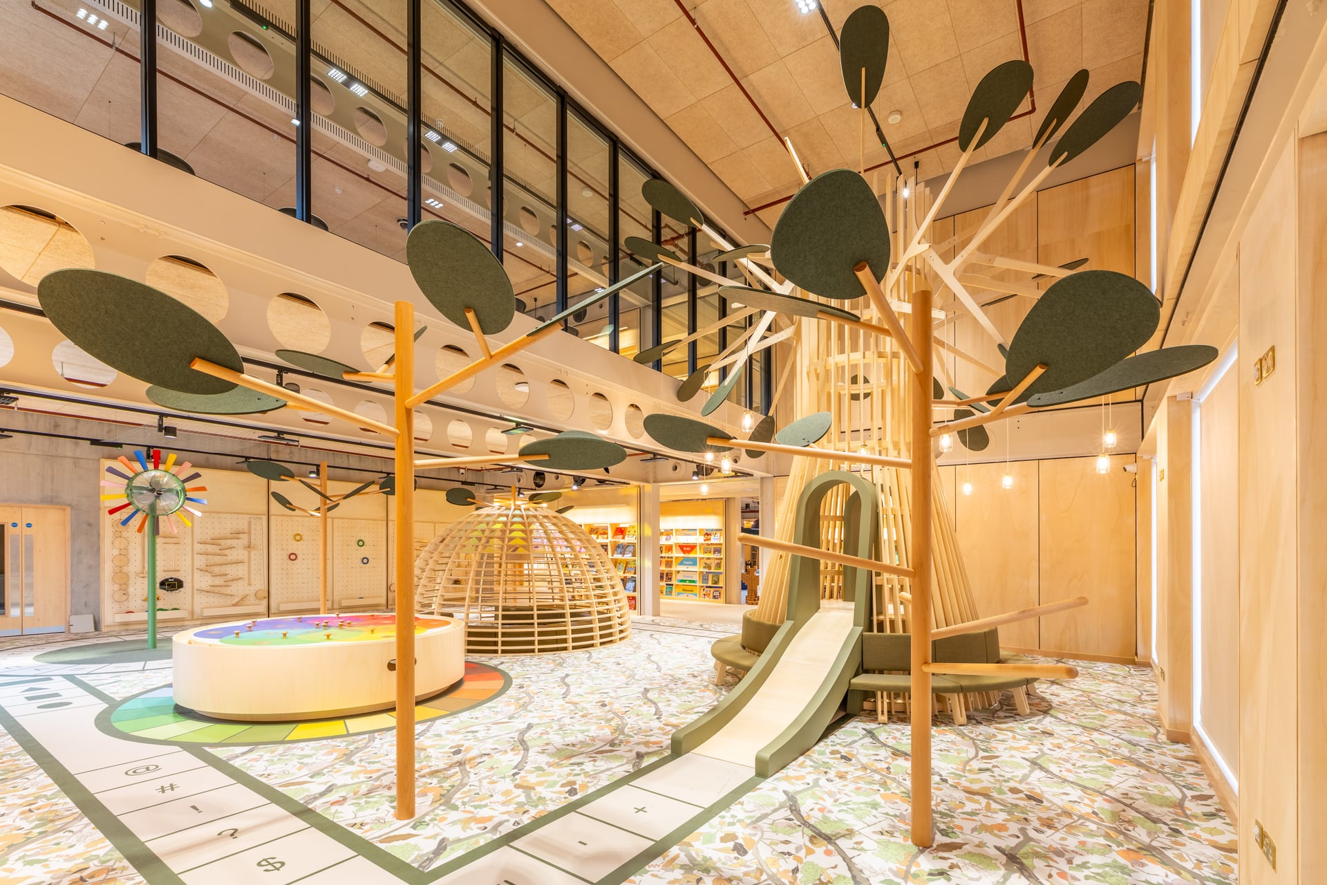 Culture_House_Interior-12 An interior of the Culture House den featuring wooden trees, a slide inside a wooden structure, a caged seating area and a large circular structure with removal pieces