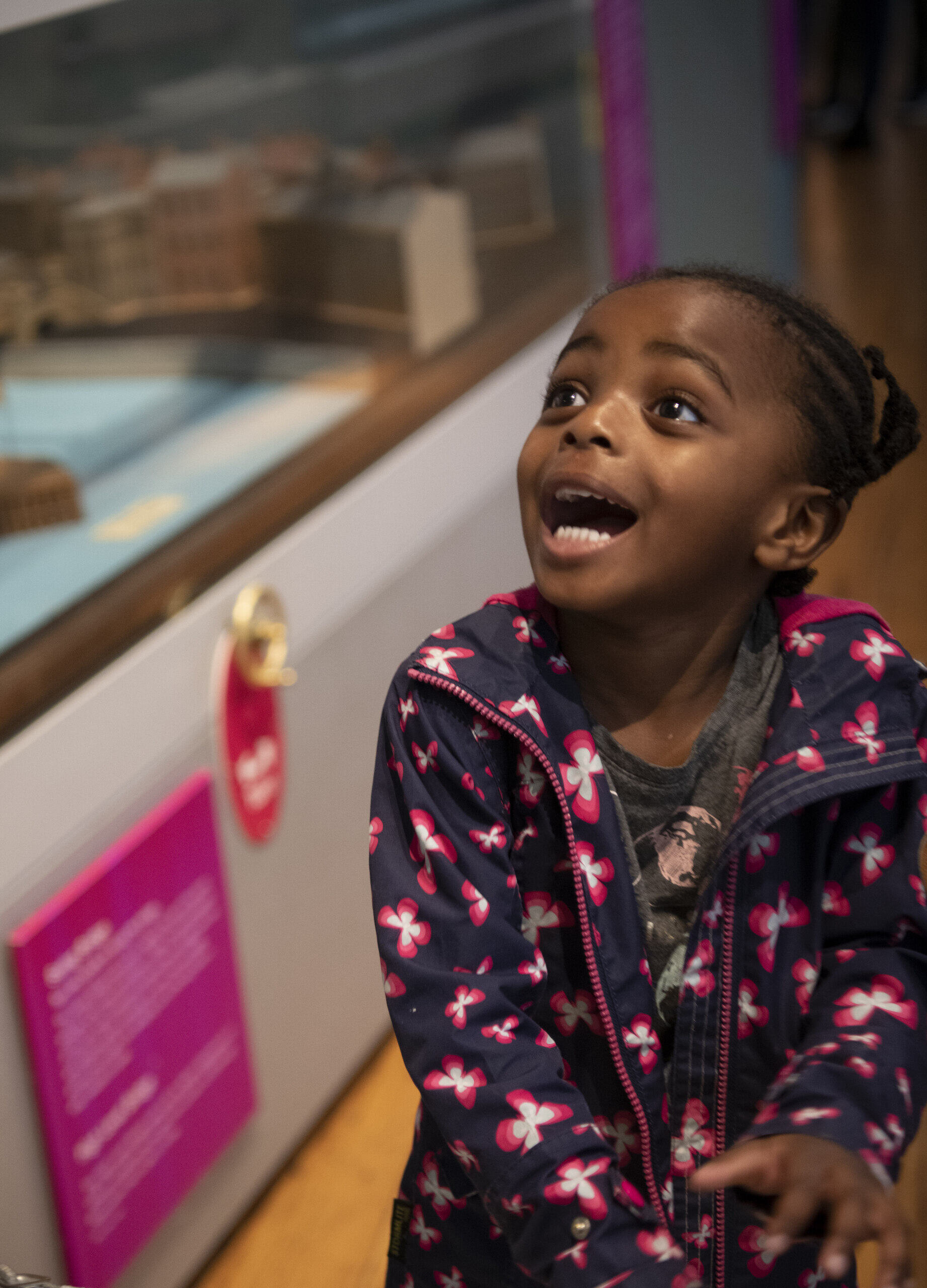 Discovery Museum 3 A young girl looks up at something out of shot. She looks excited and amazed.