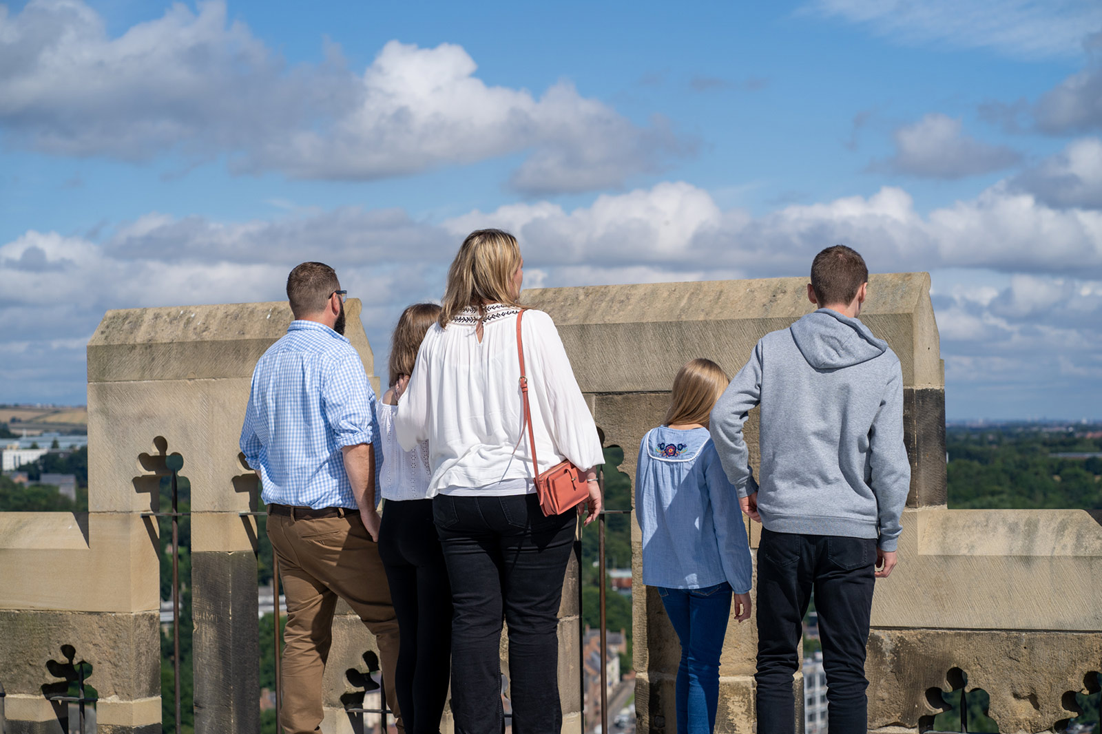 Durham-Cathedral-WEB-038 A family group look over the walls of Durham Cathedral at the city below.
