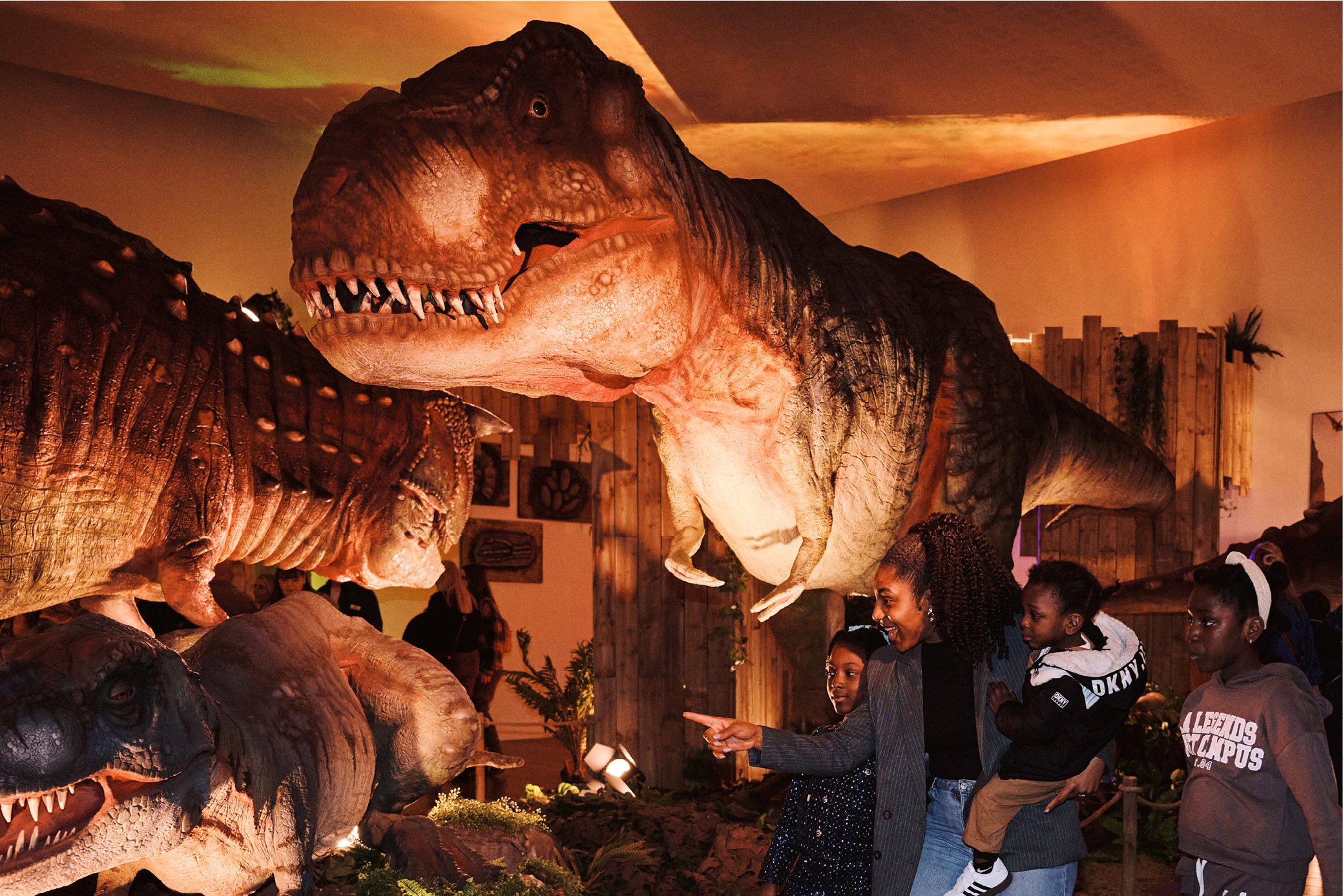 A family of three point to huge animaotronic dinosaurs