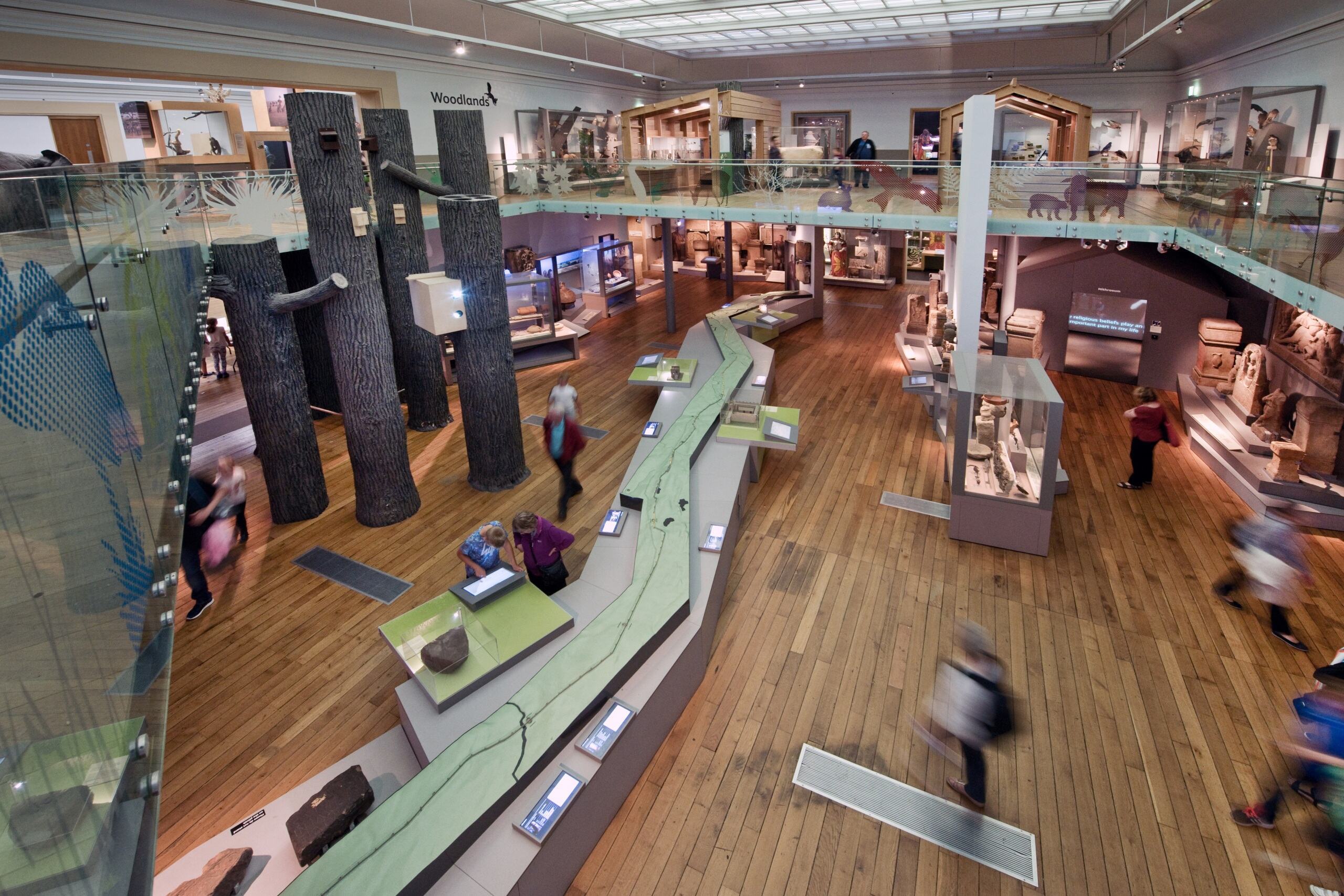 An ariel shot of the inside of the Hancock Museum in Newcastle. A long replica of Hadrian's Wall runs the length of the room. There are two floors with items from history and animals on display.