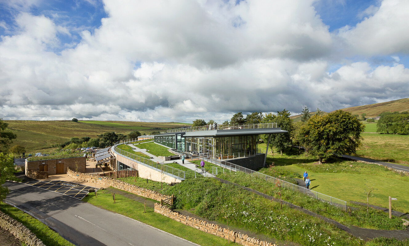 An ariel view of the Sill Discovery Centre. It is set in a landscape of green hills and trees.