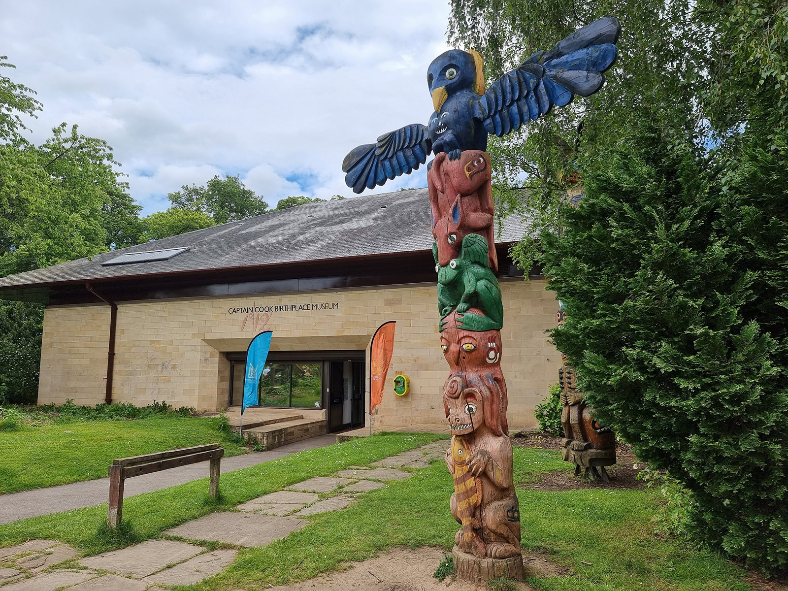 The exterior of Captain Cook Birthplace Museum with a totem pole at the entrance.