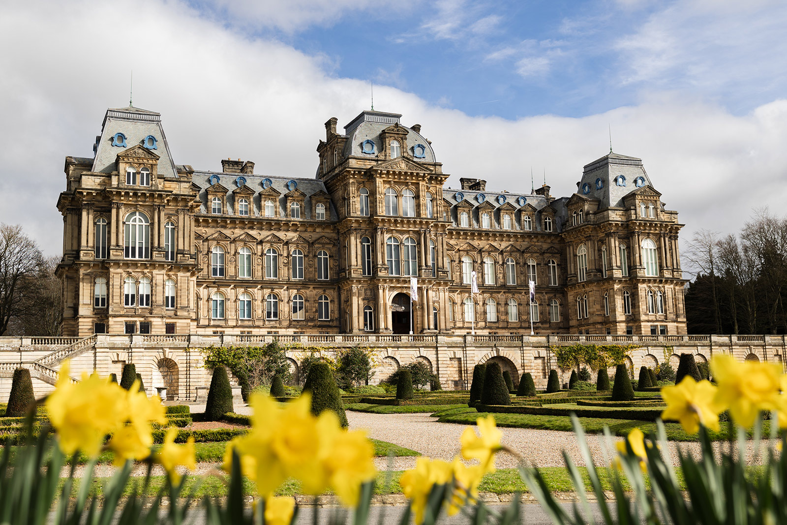 An exterior image of the Bowes Museums with daffodils in the foreground.