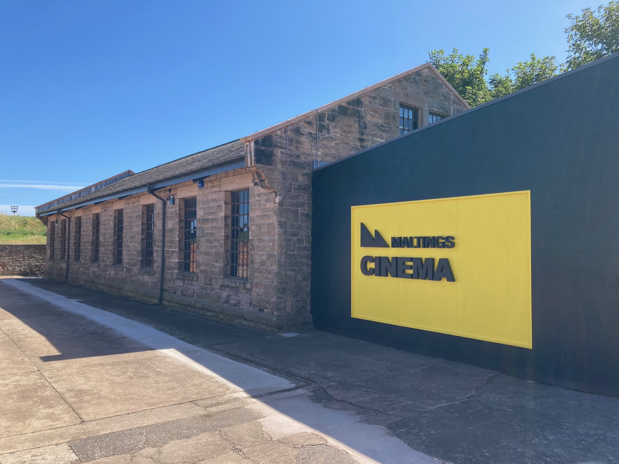 The outside of Maltings Cinema in Berwick with a large yellow sign.