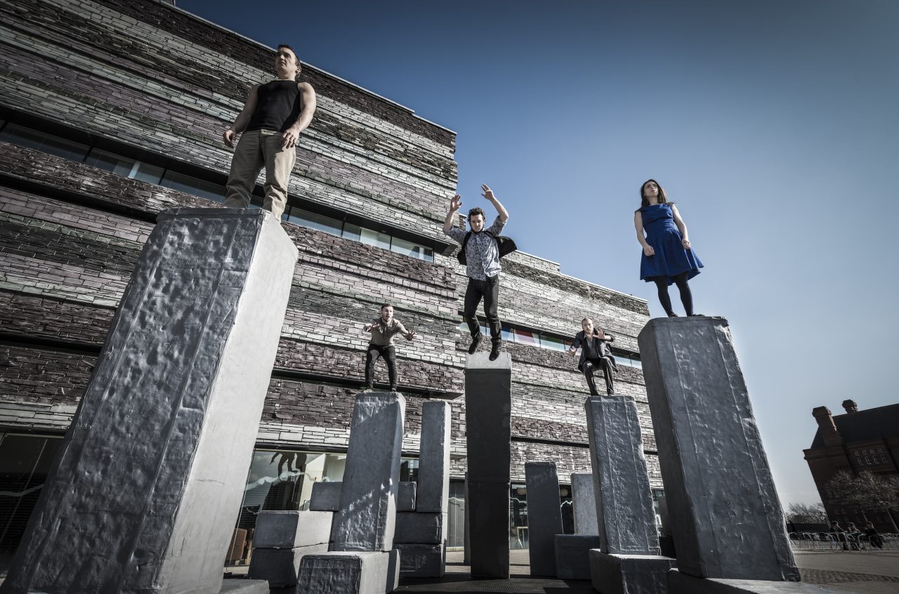 People standing on tall concrete pillars.