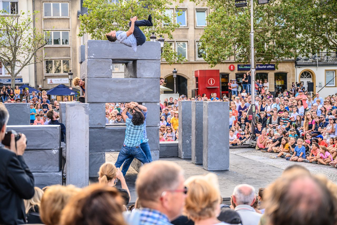Performers do acrobatics on large geometric concrete structures.
