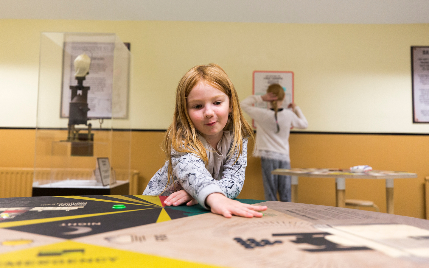 A child reaches out across an interactive interpretation board.